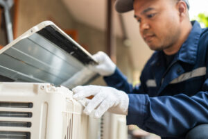 air conditioner technician working on unit