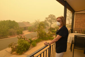 woman outside looking at smoke during wildfire