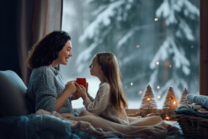 Mother and daughter enjoying winter nature in the window